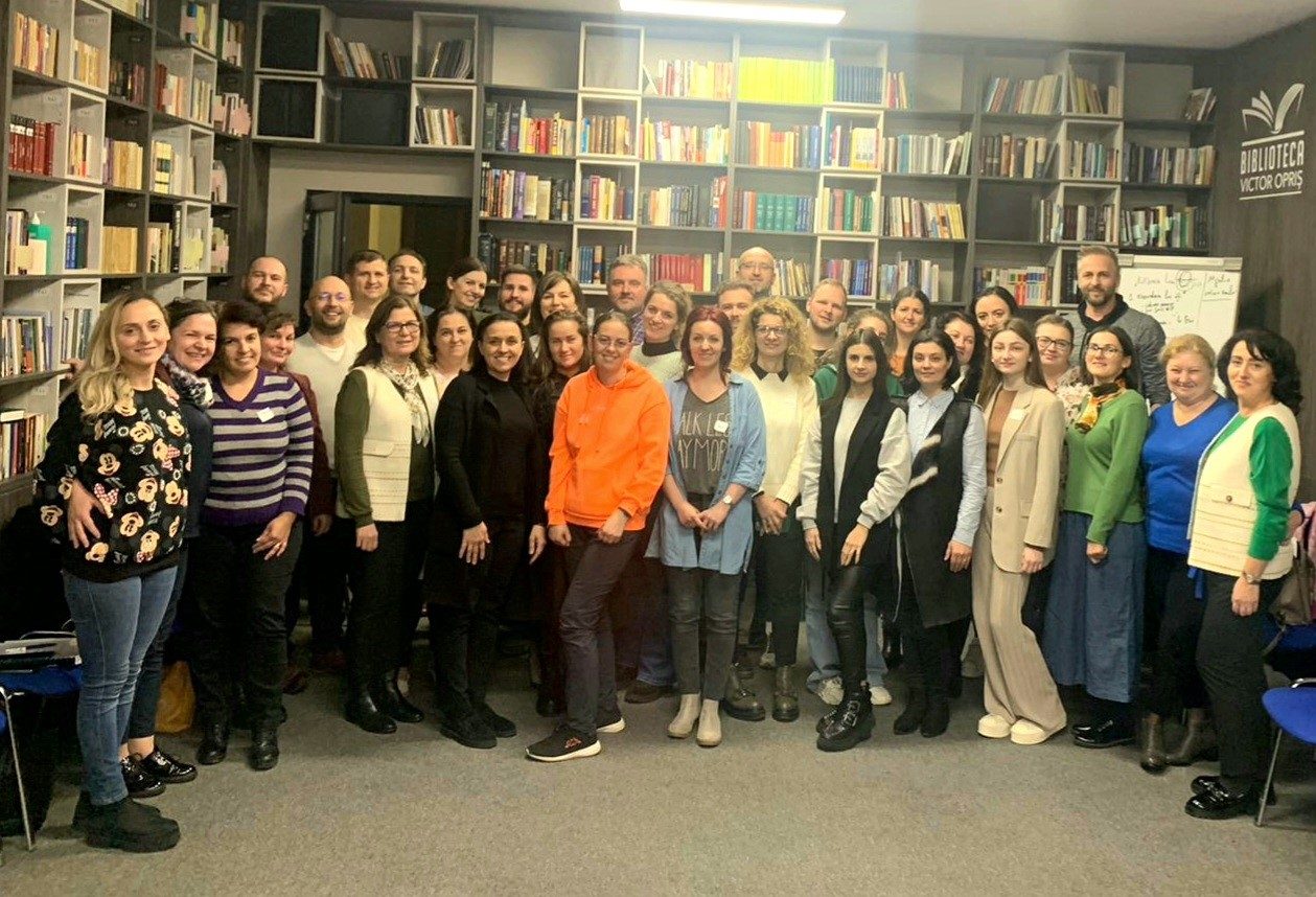 Participanți la un curs de formare ACCR, în fața rafturilor cu cărți